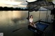 A woman sitting on a dock with a net over her head.