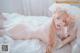 A woman in a white lingerie laying on a bed.