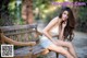 A woman sitting on a wooden bench in a park.